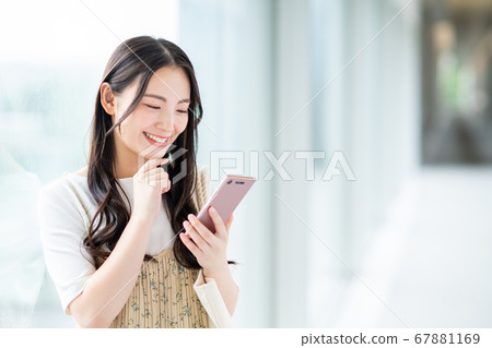 一名在校園裡操作智能手機的大學生 67881169