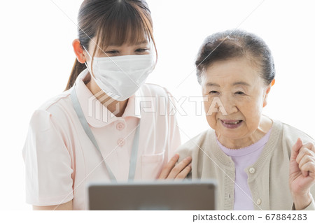 Senior woman making a video call and their assistance staff 67884283