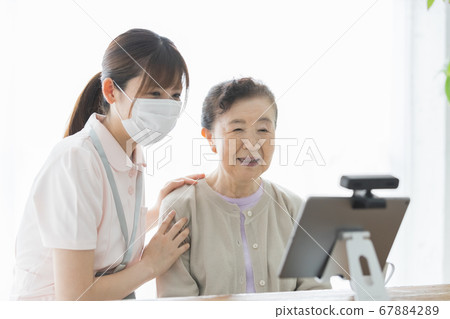 Senior woman making a video call and their assistance staff 67884289