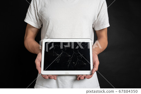 Person with a tablet with a cracked screen Person with a tablet with a cracked screen 67884350