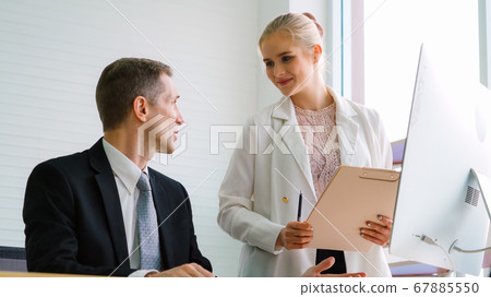 Two business people talk project strategy at office Two business people talk project strategy at office 67885550