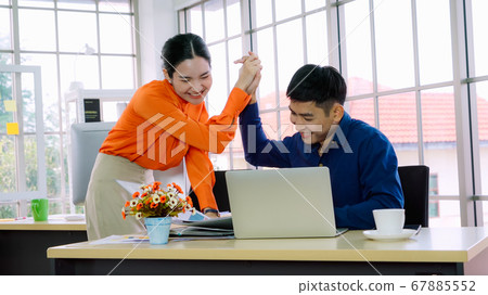 Two happy business people celebrate at office Two happy business people celebrate at office 67885552