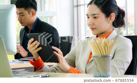 Business people working at table in modern office Business people working at table in modern office 67885554