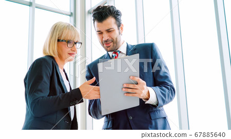 Two business people talk project strategy at office 67885640