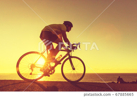 Road bike cyclist man cycling in sunset 67885665