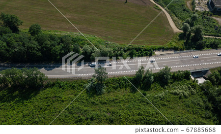 Aerial view from above of curve highway road with a car with green forest in Russia 67885668