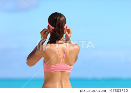 Runner putting headphones for music listening run 67885710