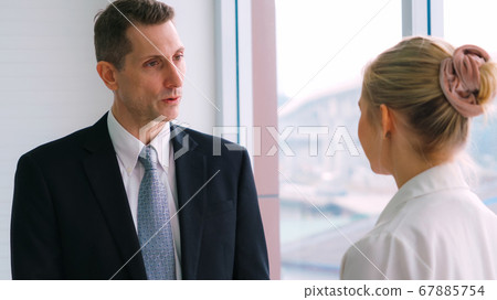 Two business people talk project strategy at office Two business people talk project strategy at office 67885754