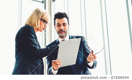 Two business people talk project strategy at office 67886044