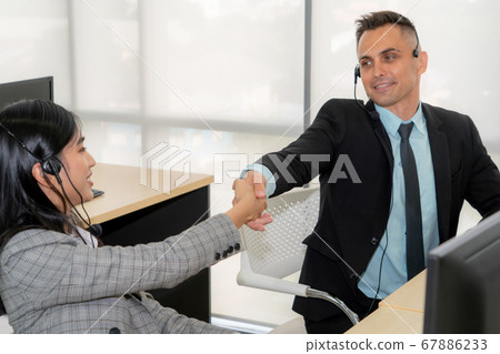 Business people wearing headset celebrate working in office Business people wearing headset celebrate working in office 67886233