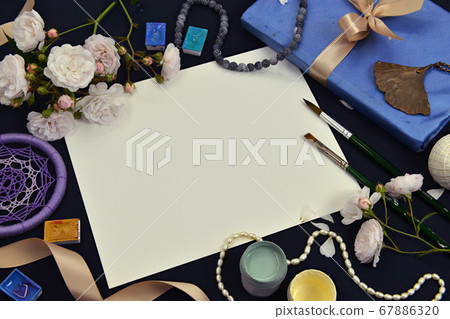 White paper sheet with book, rose flowers and artistic objects. Mystic and romantic background with copy space and blank, vintage romantic concept for mock up, top view 67886320
