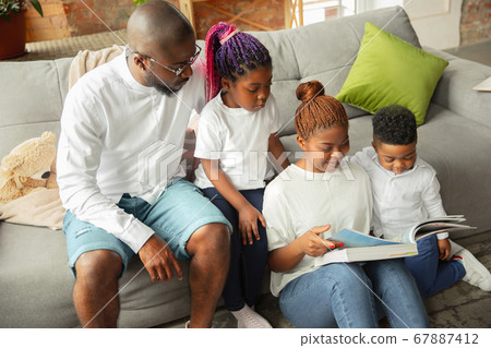 Young african family during quarantine, insulation spending time together at home Young african family during quarantine, insulation spending time together at home 67887412