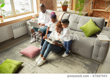 Young african family during quarantine, insulation spending time together at home 67887443