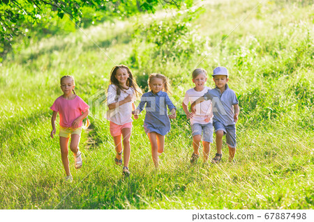 Kids, children running on meadow in summer's sunlight 67887498