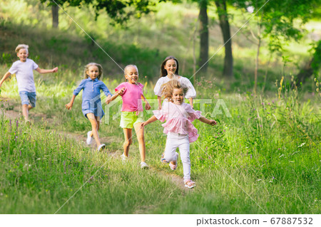 Kids, children running on meadow in summer's sunlight 67887532
