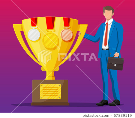Successful businessman near big gold trophy cup 67889119