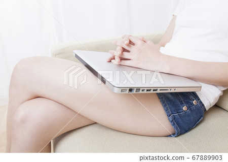Woman putting laptop on knees 67889903