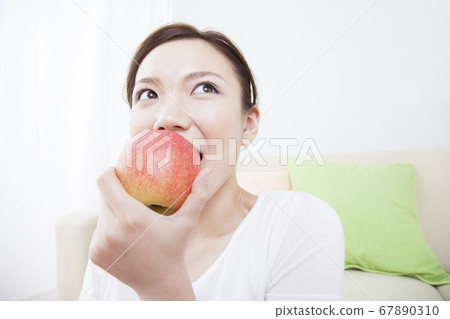 Woman eating an apple Woman eating an apple 67890310
