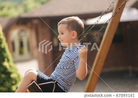 Little boy on the swing. Happy kid outdoors 67893181