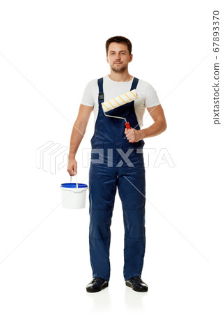 repairman holding paint roller and can with paint. 67893370