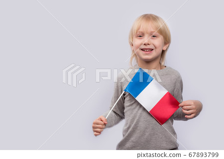 Exciting fair-haired boy holding flag of France. Exciting fair-haired boy holding flag of France. 67893799