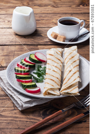Roll with cheese and herbs. Grilled pita bread with filling. Cucumber radish salad. The concept of a healthy Breakfast. Cup of coffee. 67893881