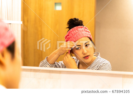 Young housewife doing hair turban and caring for the skin Young housewife doing hair turban and caring for the skin 67894105