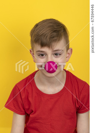 Teenager in red t-shirt with clown nose on yellow Teenager in red t-shirt with clown nose on yellow 67894446