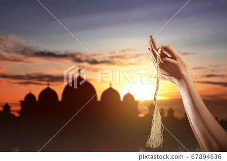 Muslim man praying with prayer beads on his hands 67894636