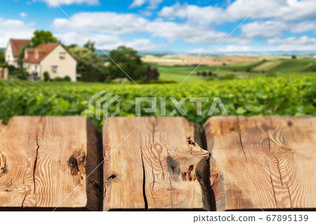 Wooden boards or countertop against blurred countryside landscape on background. Use as mockup for display or montage of your products. Close up Wooden boards or countertop against blurred countryside landscape on background. Use as mockup for display or montage of your products. Close up 67895139