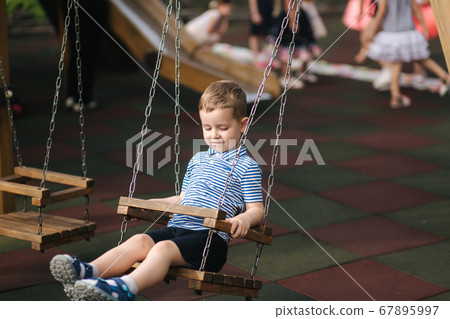 Little boy on the swing. Happy kid outdoors 67895997