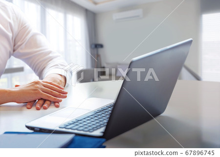 Businessman sitting with a laptop working from home 67896745