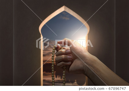 Muslim man praying with prayer beads on his hands 67896747