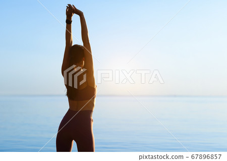 Lady preparing for cardio workout, stretching arms Lady preparing for cardio workout, stretching arms 67896857