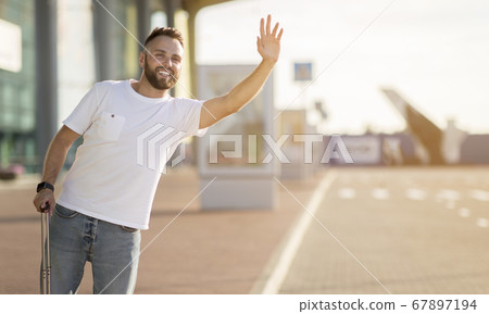 Tourist trying to catch taxi, arriving at airport 67897194