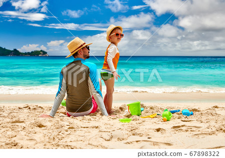 Toddler boy on beach with father 67898322