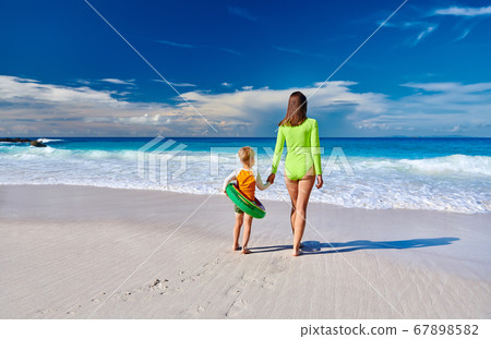 Toddler boy on beach with mother 67898582
