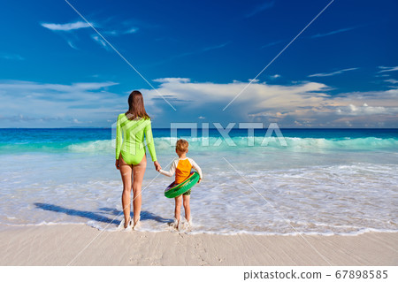 Toddler boy on beach with mother 67898585