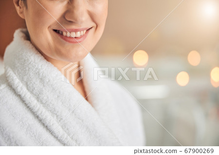 Happy young lady relaxing in spa salon 67900269