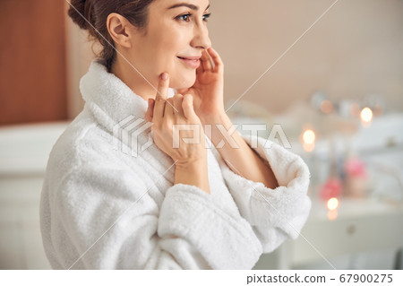 Happy attractive young lady looking away in spa salon 67900275