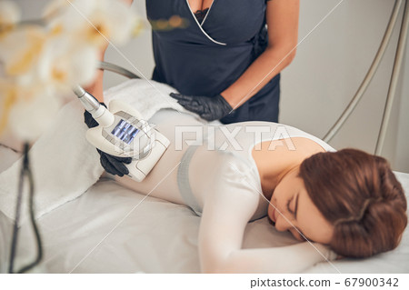 Lying female enjoying time during skincare procedure 67900342