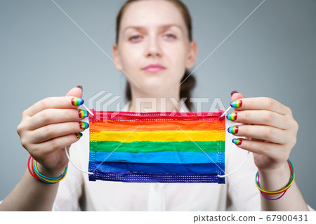 Photo of woman holding rainbow protective mask 67900431