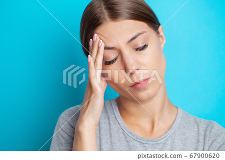 A young woman has a severe headache 67900620
