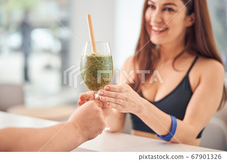 Female client rejoicing at her green smoothie Female client rejoicing at her green smoothie 67901326