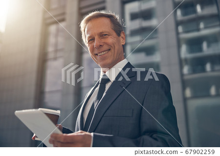 Handsome man using tablet computer on the street 67902259