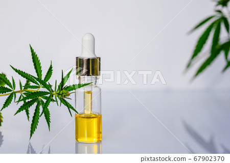 Glass bottle with CBD oil, THC tincture and hemp leaves on white background lab 67902370