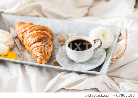 Fresh Croissant, Cup of Coffee and Ranunculus Flowers. Breakfast Fresh Croissant, Cup of Coffee and Ranunculus Flowers. Breakfast 67903196