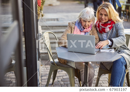 Two females chatting with their friends outdoors Two females chatting with their friends outdoors 67903197