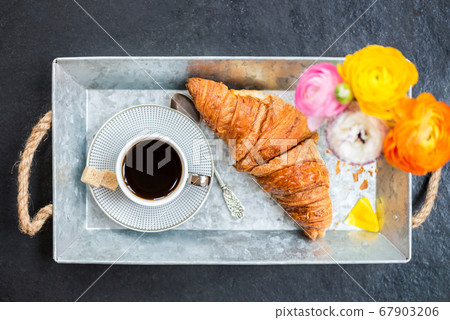 Fresh Croissant, Cup of Coffee and Ranunculus Flowers. Breakfast 67903206