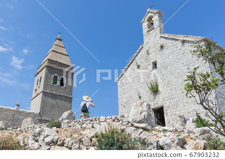 Female traveler sightseeing in an ancient costal village of Lubenice on the island of Cres, Croatia 67903232